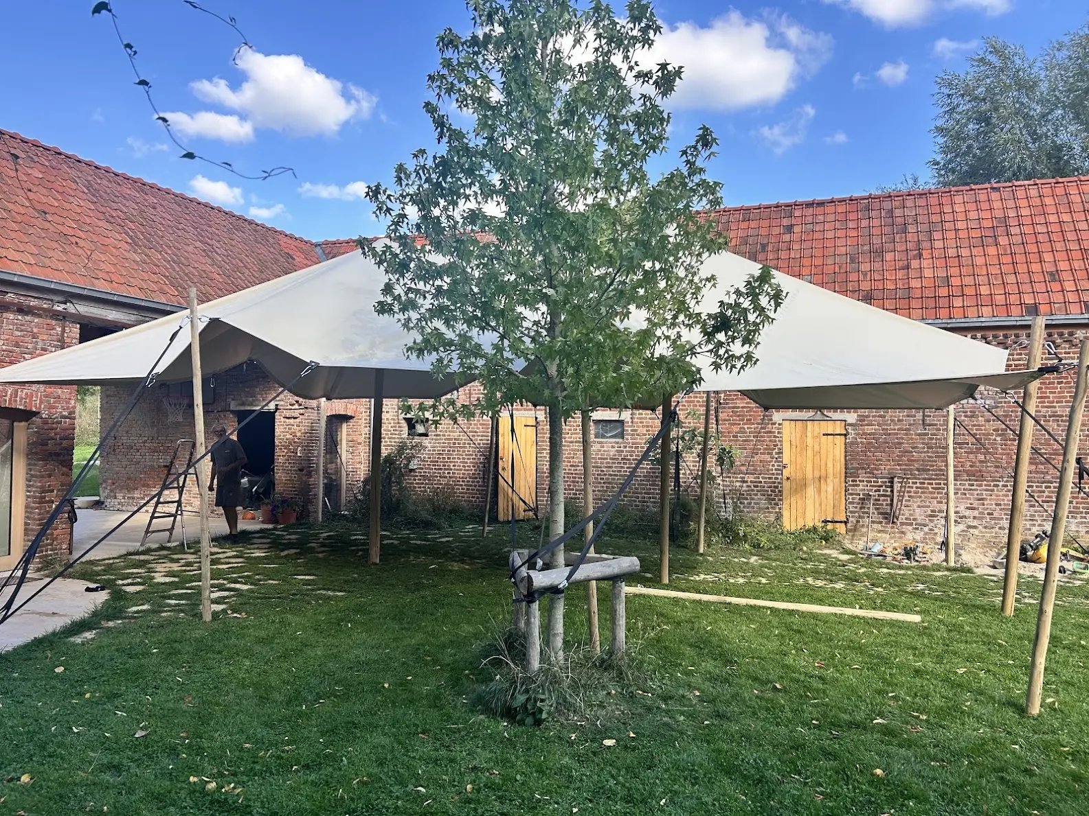 Onze zandkleurige stretchtent overdag, opgesteld op het gras